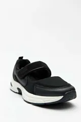 Guillermina deportiva Paddock Willemina, de color negro con suela blanca, capellada combinada de malla y material sintético, y tira con cierre de velcro en el empeine.