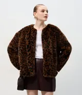 Saco de pelo sintético con estampado animal print, de corte recto y largo estándar. Presenta cuello redondo, manga larga y cierre frontal oculto.