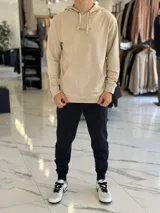 Canguro beige liviano sin felpa, con capucha y estampado en la espalda con el texto "Original Studio Copenhagen Workshop Crafted Aesthetics".