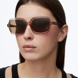 Lentes de sol con montura oversized de forma cuadrada en color rosado transparente y cristales polarizados en tono marrón.
