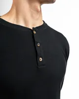 Remera tipo henley de manga larga confeccionada en tejido de algodón con textura mini piqué. Presenta un cierre frontal con tres botones y puños ajustados en las mangas.