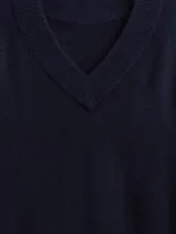 Buzo de punto con cuello en V, manga larga y puños acanalados. Diseño holgado y minimalista.