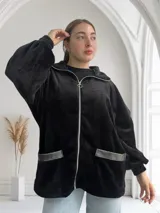 Camperón negro de tela peluche con cierre frontal, capucha y bolsillos con ribete de cuero sintético.