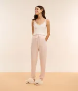 Pantalón de pijama color rosa claro, confeccionado en tejido peach touch, con cintura elástica, lazo ajustable y puños ajustados.