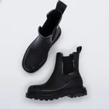 Botas tipo Chelsea de la marca Melissa, confeccionadas en material sintético impermeable con acabado mate y detalles brillantes. Presentan paneles laterales elásticos, suela de goma robusta con relieve y tirador en la parte superior trasera.