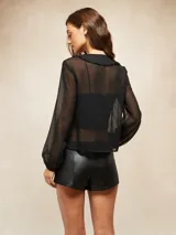 Short de tiro bajo confeccionado en cuero sintético negro, con diseño de costuras decorativas en contraste que forman figuras abstractas tipo western en el frente.