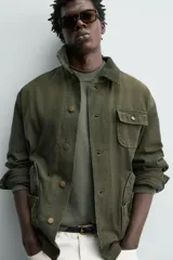 Cazadora relaxed fit de algodón color verde militar, con efecto lavado, cuello solapa de pana a tono y manga larga. Cuenta con bolsillos de plastrón delanteros y cierre frontal de botonadura.