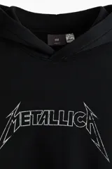 Canguro negro de corte holgado con capucha, bolsillo frontal tipo canguro y estampado gráfico de Metallica en el pecho.