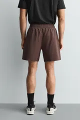 Pantalones deportivos cortos de tejido técnico ligero y elástico, con cintura elástica ajustable, bolsillos frontales y aberturas laterales en el bajo.