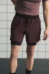 Short deportivo de doble capa en tejido funcional con tecnología DryMove para absorción de sudor. Presenta corte estándar, cintura elástica con cordón ajustable, bolsillos laterales y aberturas en el bajo. Incluye una capa interior tipo biker con bolsillo y bucle trasero para accesorios.