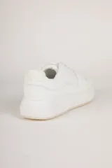 Zapatillas blancas de símil cuero con recortes en distintas texturas y plataforma de 4cm de alto.