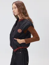 Chaleco de corte cuadrado con diseño bicolor en tonos terracota y crema. Presenta cierre frontal metalizado, parches de nylon en el pecho, interior forrado en corderito y cordón ajustable en el ruedo.