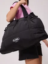 Bolso tipo tote bag de diseño acolchado en color negro, con correas ajustables y cierre lateral. Presenta el logo de la marca Rusty en la parte frontal.