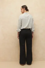 Pantalón de lino color verde, de tiro alto, con bolsillos en el frente y atrás, y corte recto.