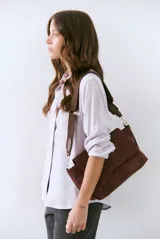 Camisa blanca de manga larga con cuello clásico, cierre de botones frontal y bolsillo de parche en el pecho.