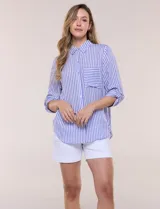 Camisa de corte clásico y silueta relajada con diseño de rayas verticales en azul y blanco, cuello camisero tradicional, cierre frontal con botones y bolsillo aplicado en el pecho con rayas horizontales. Cuenta con mangas largas con presillas para arremangar y ruedo redondeado.
