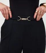 Pantalón de vestir negro de corte recto y ajuste entallado. Presenta una cintura estructurada con un adorno metálico decorativo en el centro y bolsillos laterales. Confeccionado en una mezcla de poliéster, viscosa y elastano.