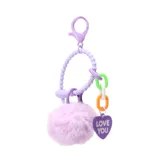 Llavero con gancho metálico y argolla plástica, con pompón de pelo sintético color lila y dije de corazón con la inscripción "Love You".