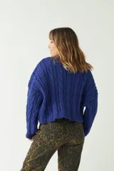 Sweater verde esmeralda de punto con diseño trenzado y textura en relieve, fit amplio y cómodo, con hombros caídos y cuello redondo.