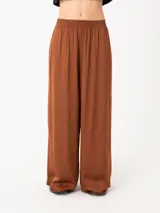 Pantalón color marrón óxido de corte amplio con elástico en la cintura y bolsillos laterales.