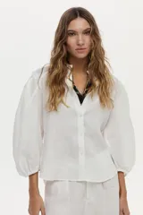 Camisa de lino blanca con mangas abullonadas y diseño para anudar al frente.