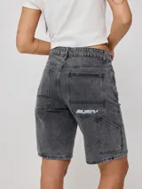 Bermuda de jean azul oscuro, corte recto y largo hasta la rodilla. Confeccionada en denim 100% algodón, con bolsillos delanteros y traseros.