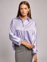 Camisa lila de satén, corte amplio, cuello solapa, manga larga y bolsillo de parche en el pecho.