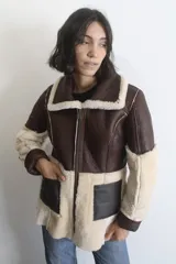Campera reversible confeccionada en napalán de cuero genuino, con cierre frontal y diseño de textura combinada de piel y cuero liso.