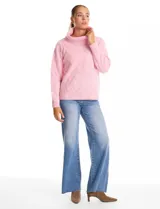 Buzo de punto grueso con textura en relieve, de cuello volcado y mangas largas con hombros caídos. Presenta puños y ruedo con terminación en rib.