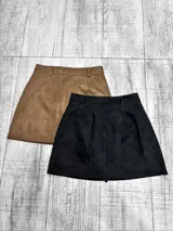 Pollera corta de gamuza con short interno incorporado, diseño de tiro medio con trabillas para cinturón.