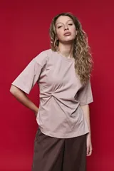 Remera de manga corta color blanco con cuello redondo y detalle de frunce lateral que aporta movimiento y una silueta entallada.
