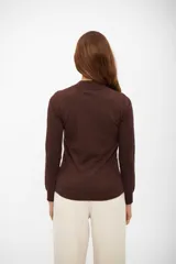 Polera de tejido fino color marrón oscuro, con cuello simulado (mock neck) y manga larga.