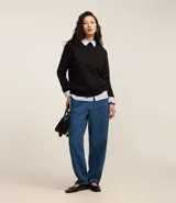 Sweater de punto negro con cuello redondo y mangas largas, diseñado con un calce clásico y versátil.