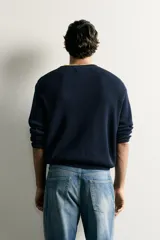 Sweater de punto regular fit en color azul marino, confeccionado en algodón. Presenta cuello redondo con botonadura decorativa en el hombro, manga larga y acabados en rib.