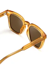 Lentes de sol con armazón de acetato biodegradable en color ámbar translúcido y diseño cuadrado ligeramente extragrande. Cuentan con lentes oscuros con protección UV 400.