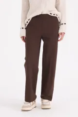 Pantalon de vestir corte recto, con tiro medio y cierre frontal. Presenta un diseño clásico y minimalista en color chocolate.