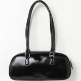 Bolso tipo baguette negro de cuero sintético con doble asa corta y cierre superior con cremallera.