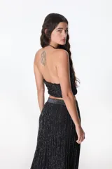 Top corto de tejido de punto color crudo con rayas horizontales marrones, escote halter y espalda descubierta.