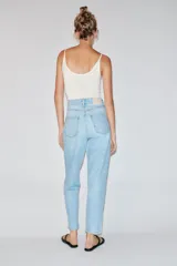 Pantalón jeans Z1975 de tiro alto y diseño mom fit, color azul claro con lavado desgastado, de corte tobillero y cinco bolsillos. Cierre frontal con cremallera y botón metálico.