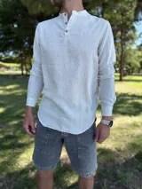 Camisola de lino color beige de manga larga, con cuello mao y cierre frontal parcial de tres botones.