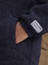 Campera con capucha confeccionada en una combinación de tejido técnico y sherpa, con cierre frontal completo y puños elásticos.
