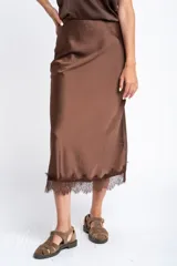 Falda midi negra de acabado satinado, corte al bies, con detalle de encaje en el ruedo.