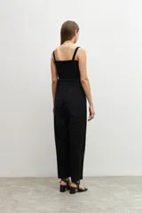 Mono negro de corte palazzo, con breteles finos y escote recto con detalle de smock.