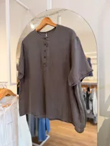 Blusa de lino color gris oscuro, de calce oversize y manga corta, con escote redondo y cartera frontal con botones a contratono.