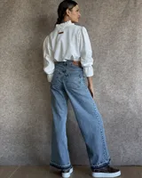 Pantalón de jean estilo wide leg con costuras verticales frontales, tiro alto y bolsillos laterales.