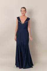 Vestido largo de fiesta azul marino, corte sirena, con escote en V y apliques de piedras bordadas en el escote.