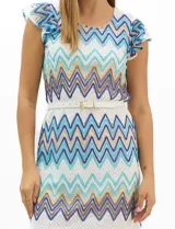 Vestido midi confeccionado en tejido de punto calado, con patrón geométrico en zigzag en tonos blanco, marrón, tostado y azul. Presenta escote a la base, mangas cortas con volados en los hombros, silueta recta y forro interior a tono. Incluye un cinturón fino con hebilla metálica.