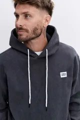 Buzo con capucha tipo canguro confeccionado en tela de corduroy color marrón. Presenta cordones blancos en contraste, bolsillo frontal tipo canguro y logo bordado sutil en el pecho.