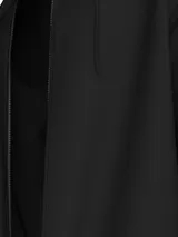 Buzo con capucha y cierre frontal completo, color negro, con puños y dobladillo en punto canalé. Presenta una cinta decorativa con el logo de la marca a lo largo de la cremallera.