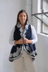 Chaleco abierto de lana en color azul marino, con diseño de bordes en contraste con estampado floral en tonos claros. Presenta un corte holgado y sin mangas.